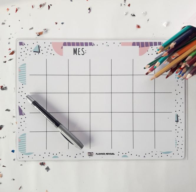 Top view of a monthly planner with a pen and colored pencils, perfect for organizing your schedule.